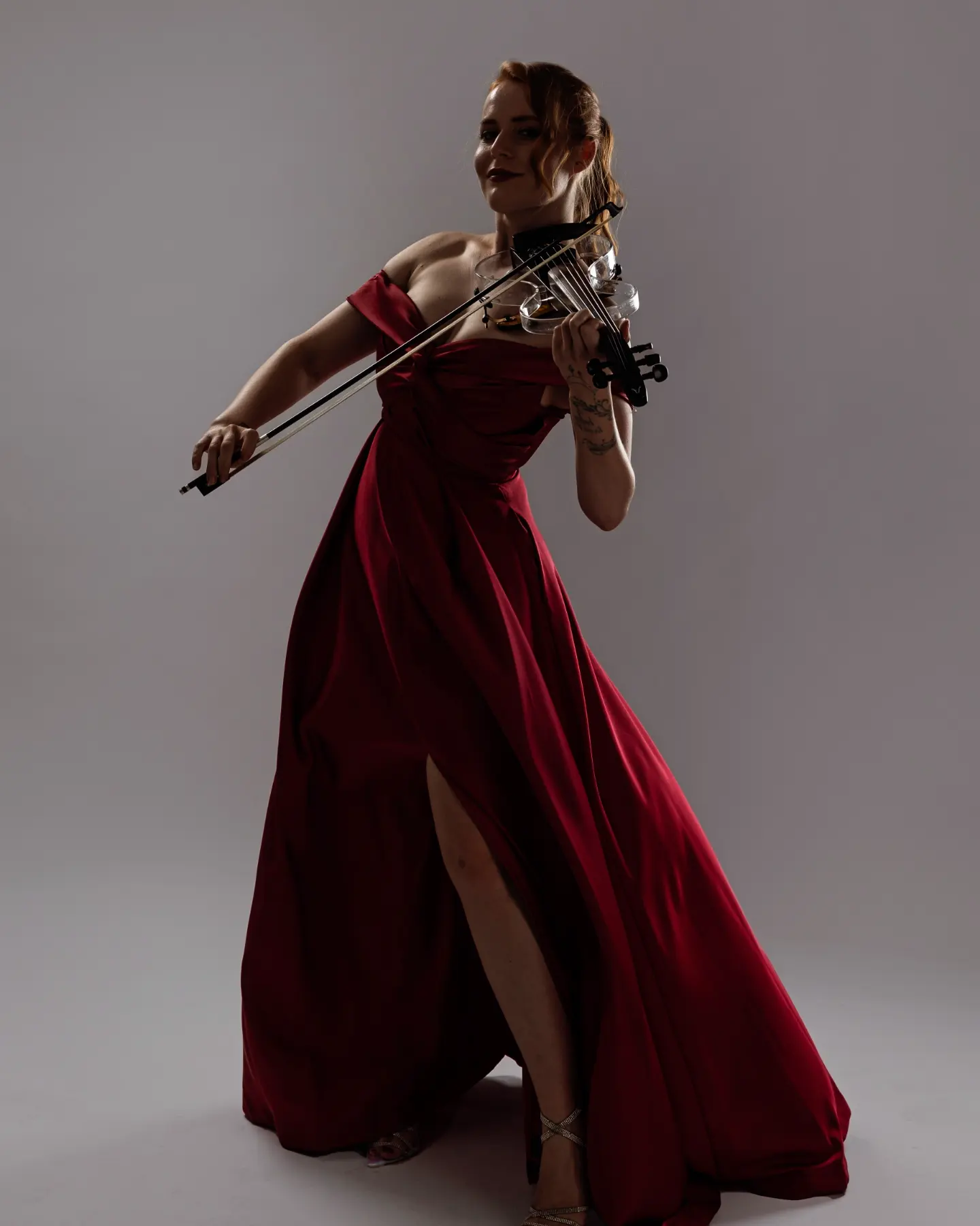 Ekaterina playing violin in a beautiful red dress