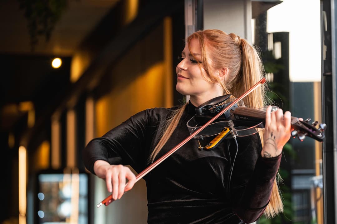 Ekaterina playing violin in front of the restaurant in the element