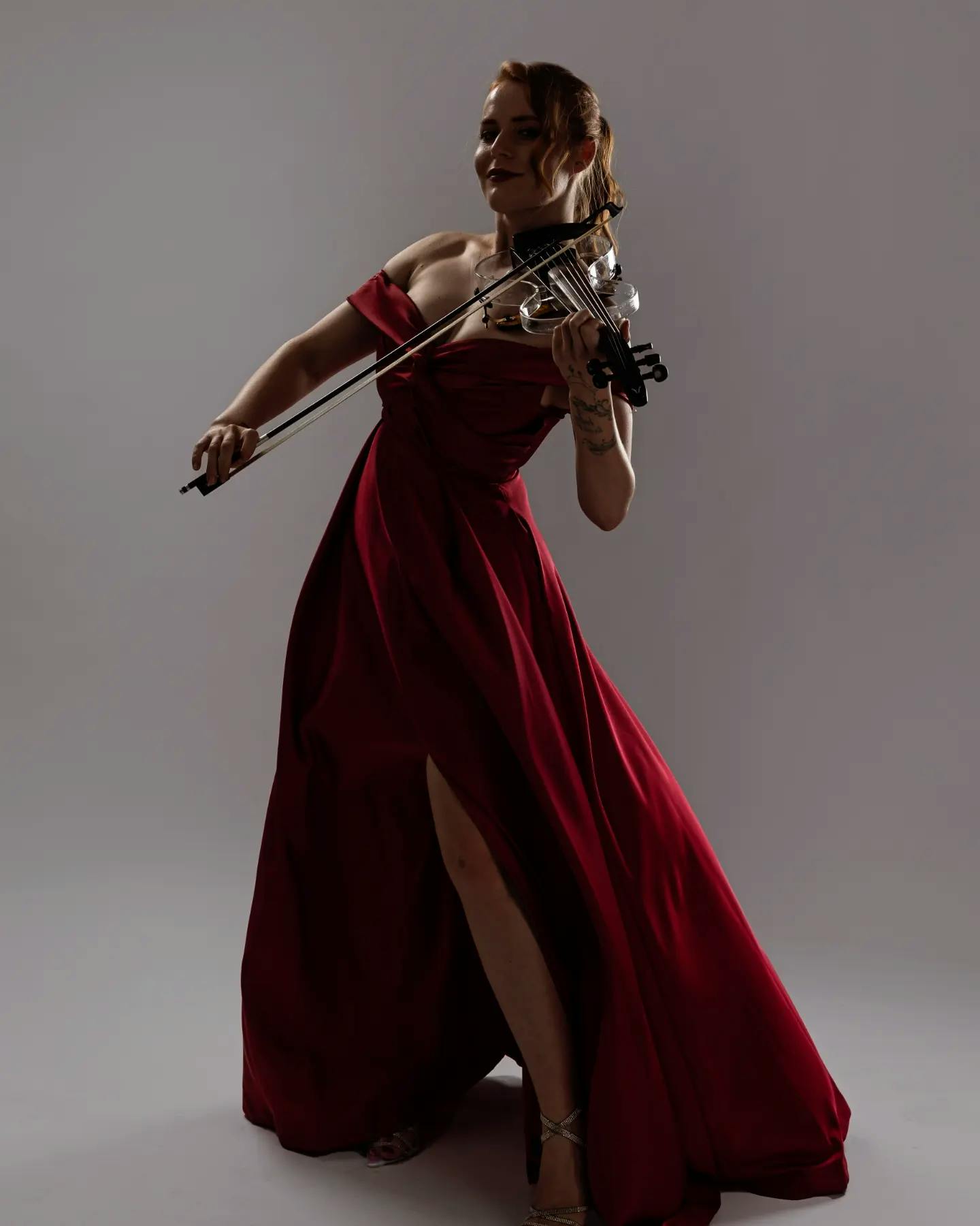 Ekaterina playing violin in a beautiful red dress